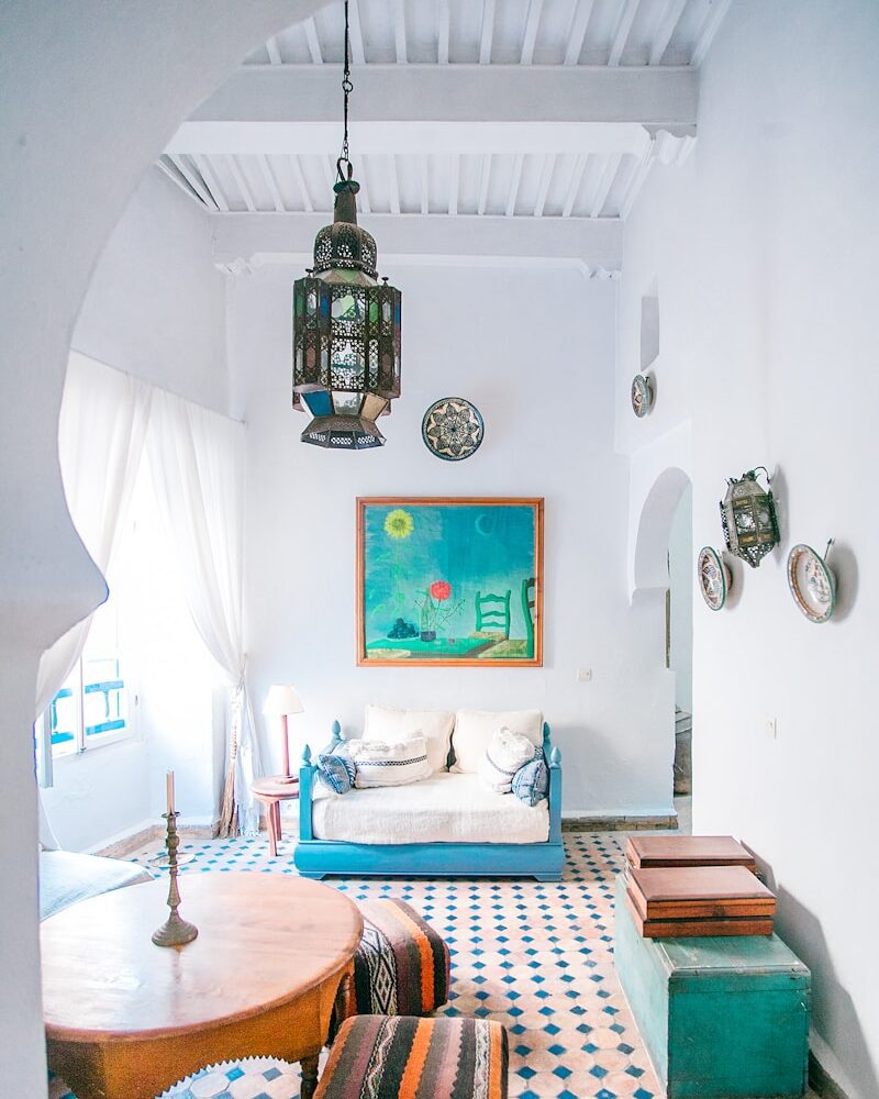 round brown wooden table with two brown ottomans