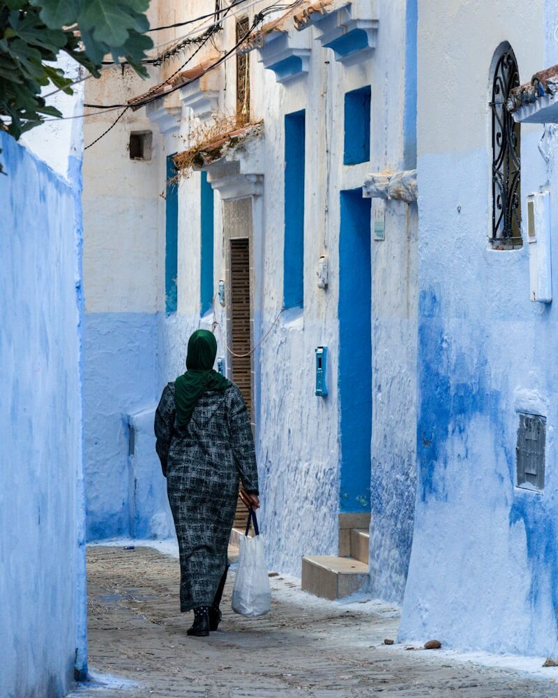 A woman walking down a narrow alley way