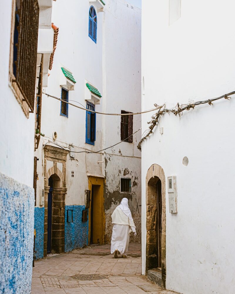 a person in a white robe walking down a street