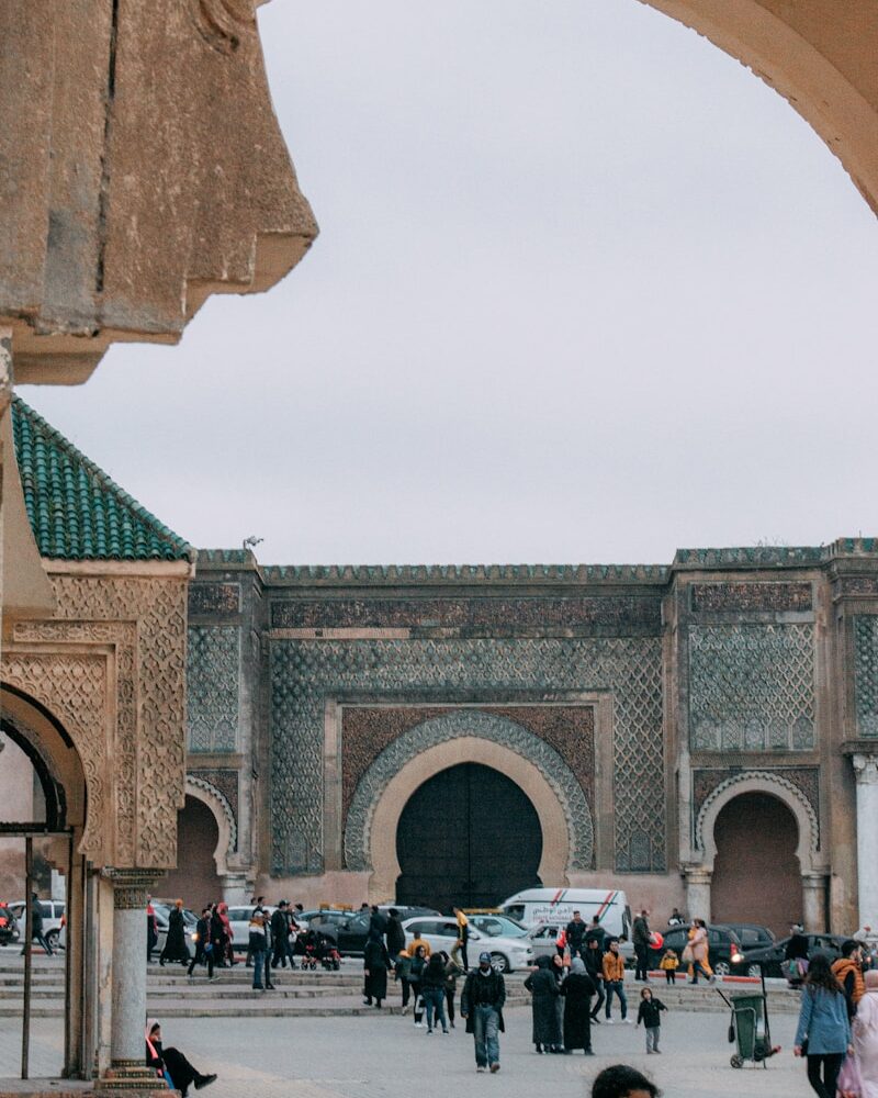 people sitting on chairs near brown concrete building during daytime