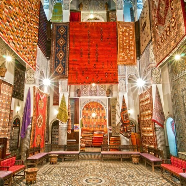 Stunning display of traditional Moroccan carpets in a Fès shop, showcasing vivid colors and intricate patterns. tours from fes